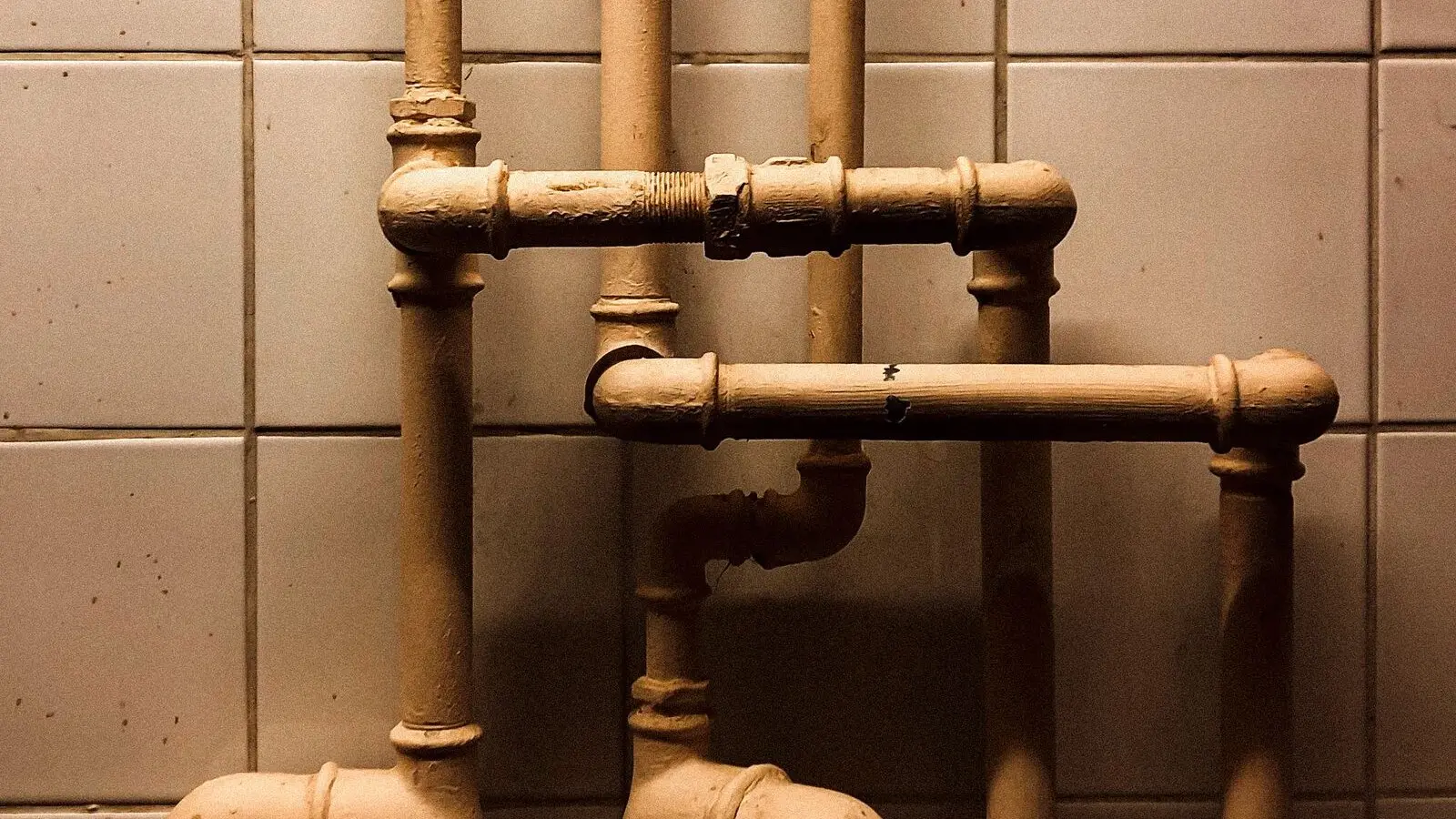 The replacement copper run, clipped and routed cleanly against tile