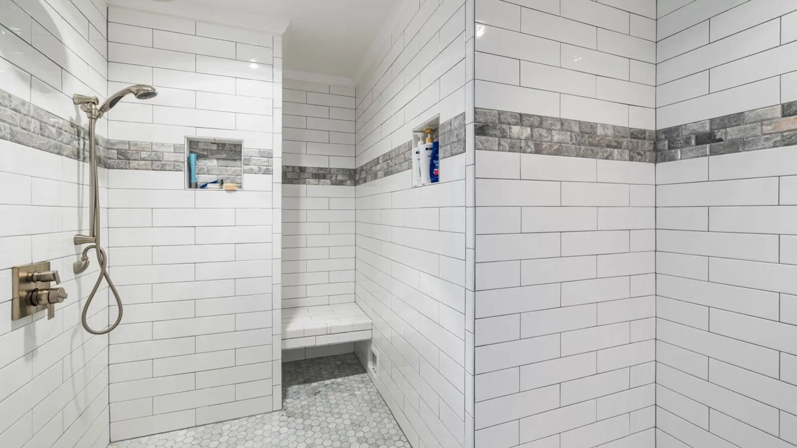 The same space after conversion to a white tiled walk-in shower